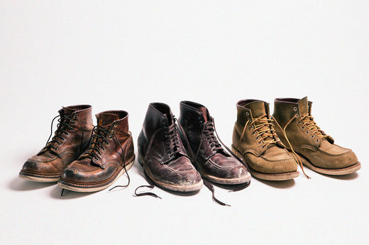 Three pairs of worn leather boots in different shades of brown and black, displayed in a row against a light background