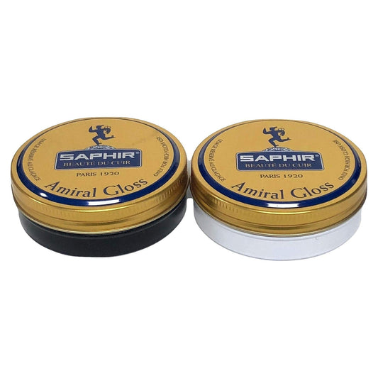 Two containers of Saphir Beaute du Cuir Amiral High Gloss Wax Polish, one with a black lid and the other with a white lid, both labeled with the product name and the brand's logo.