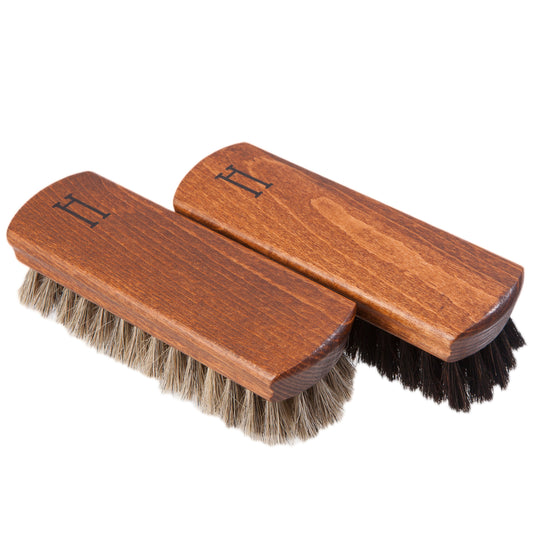 Two wooden polishing brushes with horsehair bristles, one displayed in front view and the other in side view, both with the letter 'H' on the top handle.
