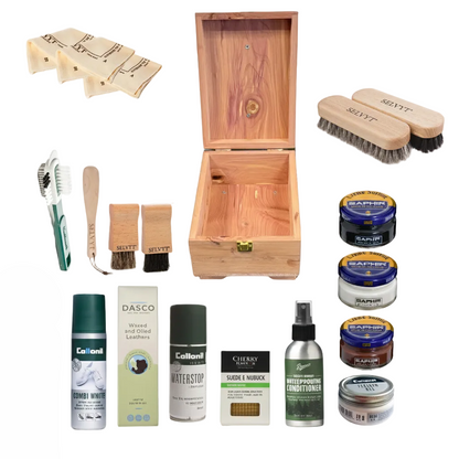 Collection of shoe care products including a wooden box, brushes, and containers on a white background.
